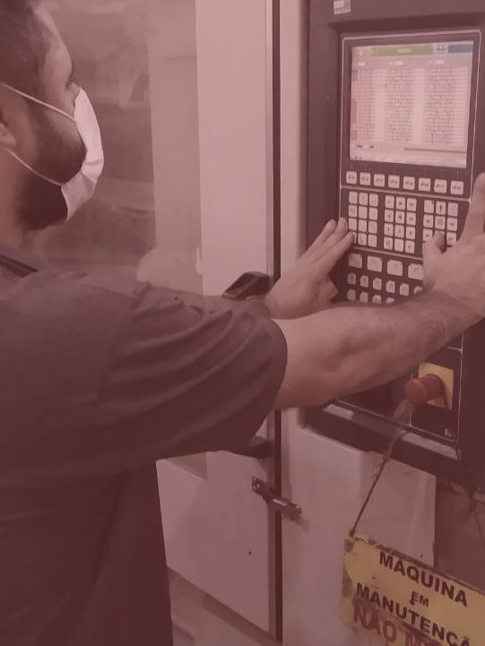 Técnico Injet operando painel de injetora durante manutenção